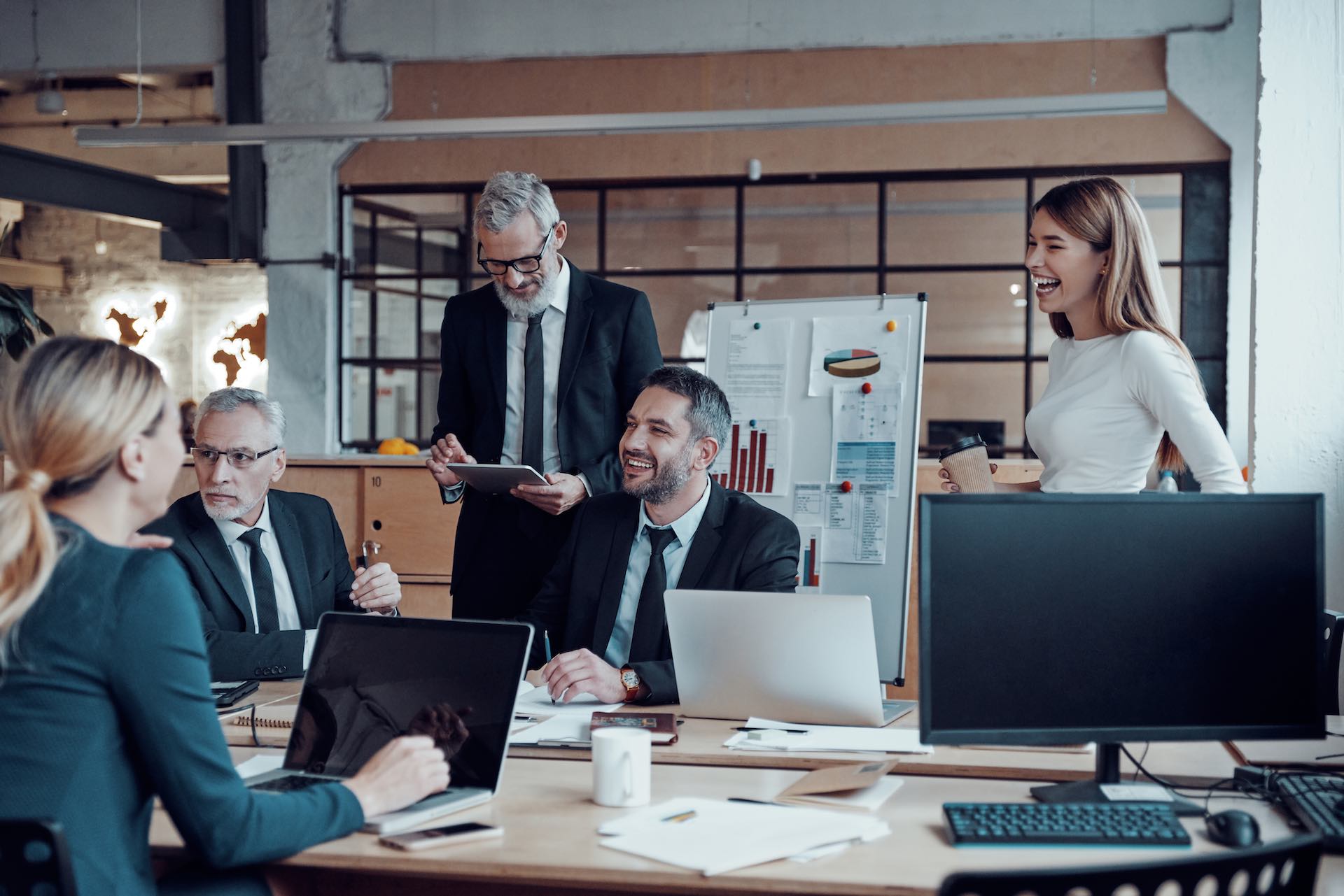 Modern marketing professionals in elegant formalwear discussing fresh business ideas while working in the office