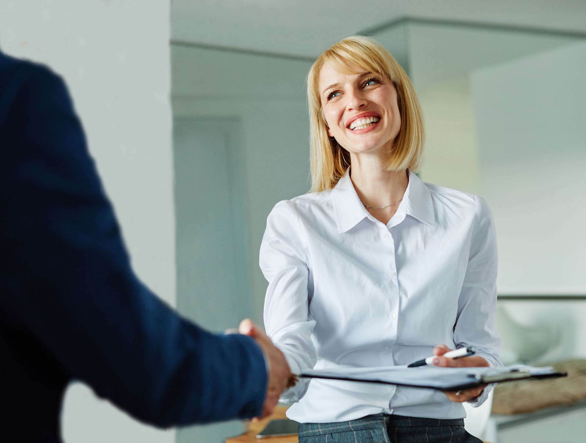 portrait of a young beautiful businesswoman and businessman shaking hands introducing each other in the office