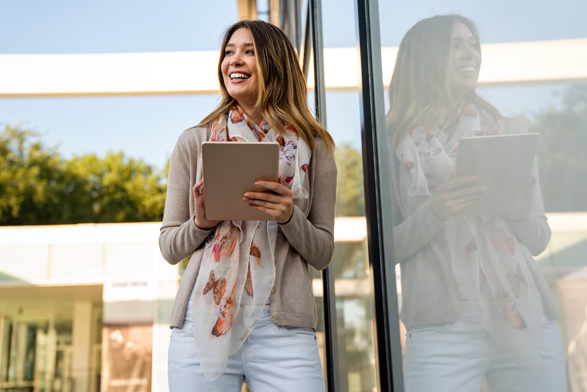 Digital device people work social media student concept. Happy young woman using digital tablet outdoors.