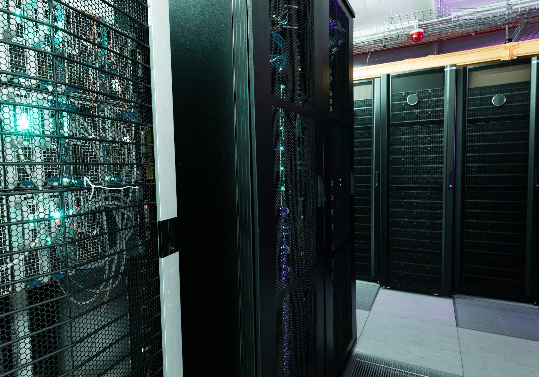 Data center with multiple rows of fully operational server racks. modern cloud computing technology concept.