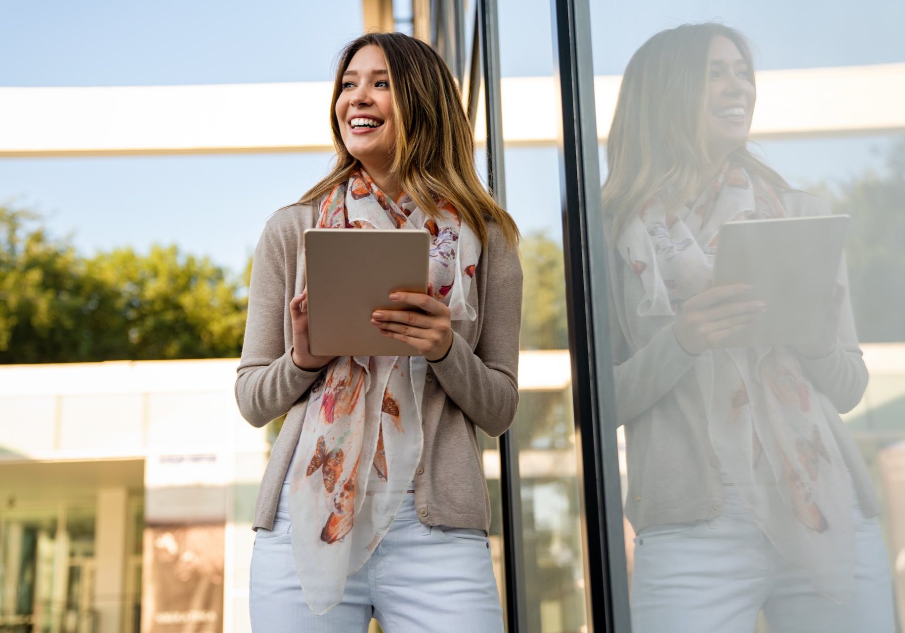 Digital device people work social media student concept. Happy young woman using digital tablet outdoors.