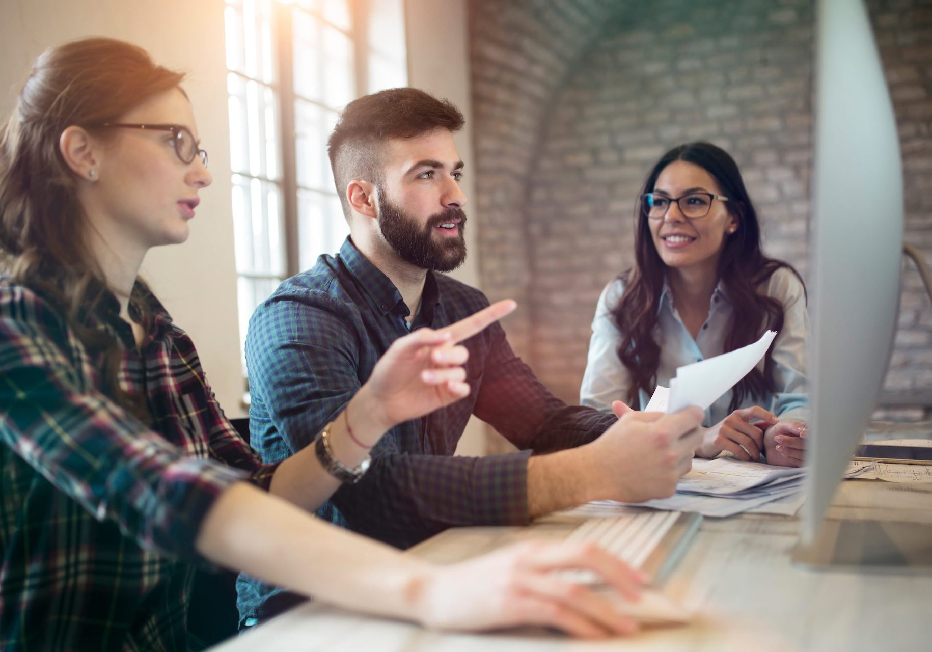 Group of young designers working as team in office