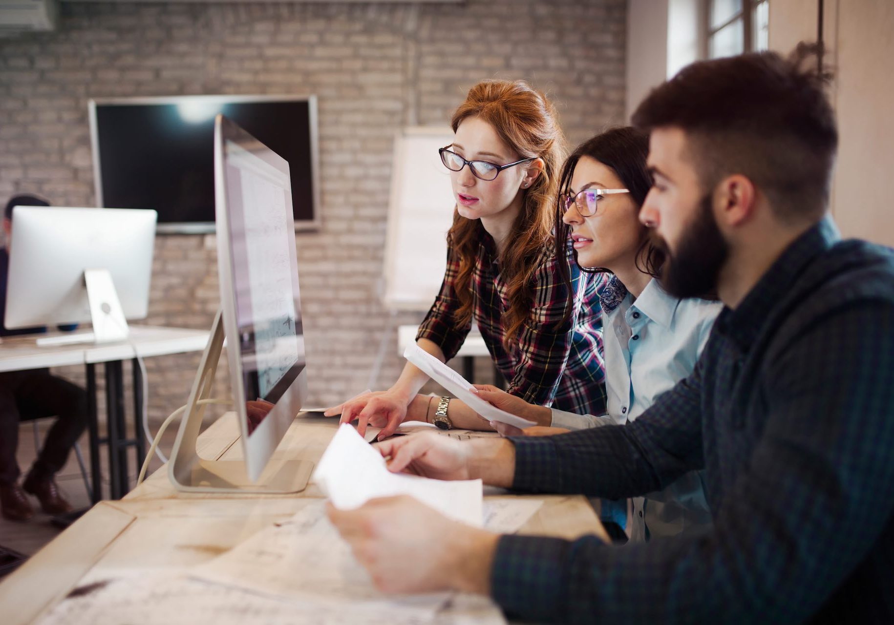 Group of young designers working as team in office