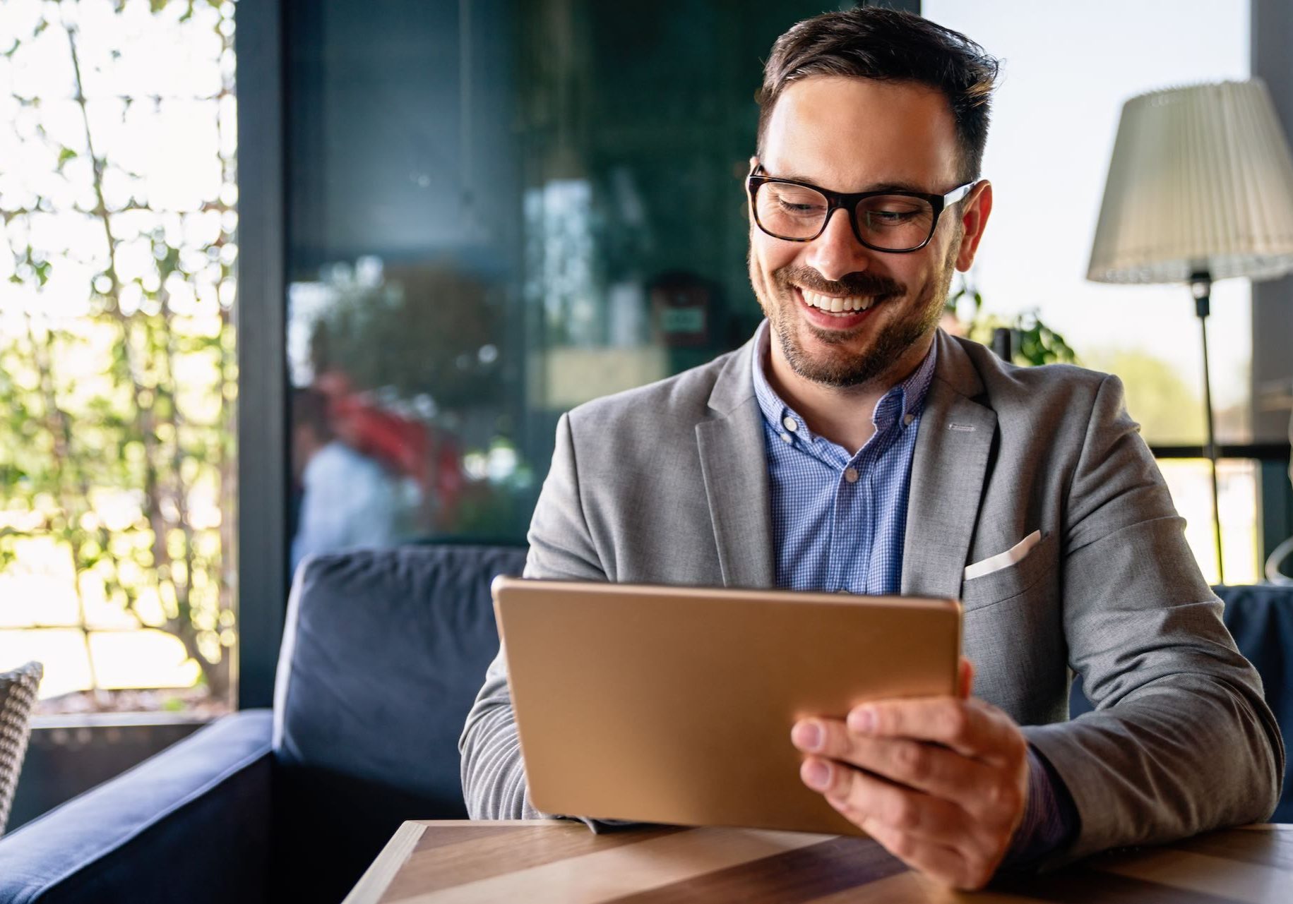 Portrait of happy succeffsul young business man, leader, ceo, manager using digital tablet to work. Business technology concept.